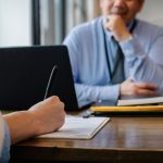 Candidata preenche formulário durante atendimento para emprego em um escritório.