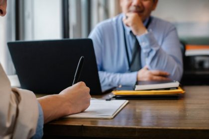 Candidata preenche formulário durante atendimento para emprego em um escritório.