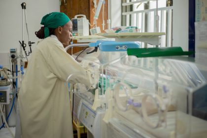 Médico atende recém-nascidos em incubadoras em uma unidade hospitalar neonatal.