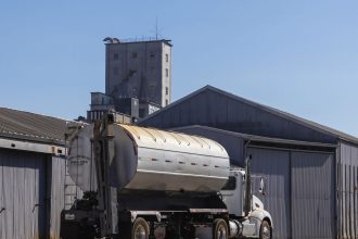 Semirreboque estacionado em um armazém industrial de grãos sob céu aberto.